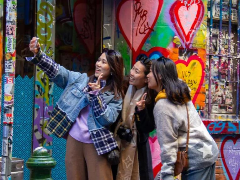 Three happy ladies snap a selfie in Melbourne’s famous Hosier Lane