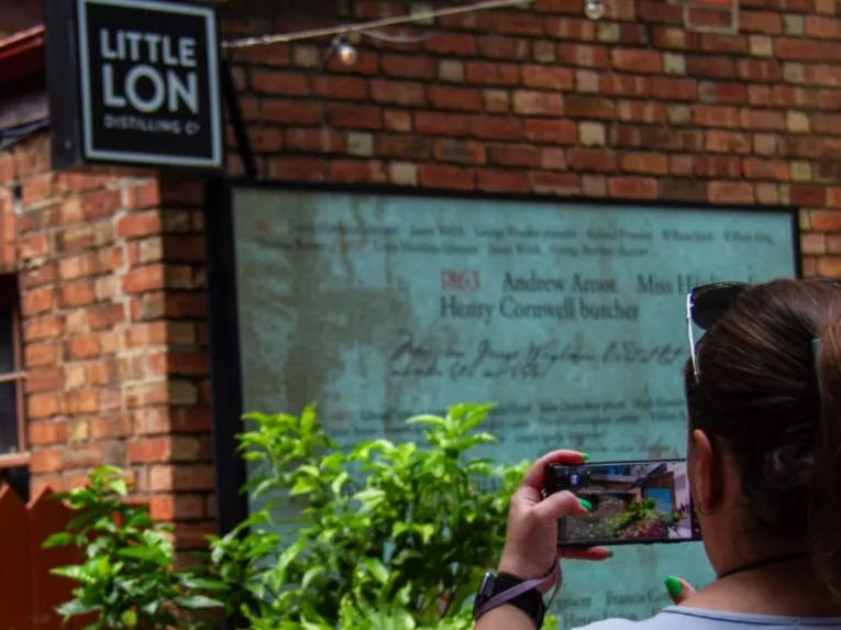 Person taking a photo of a historic building in Little Lon during the Melbourne City Discovery Tour