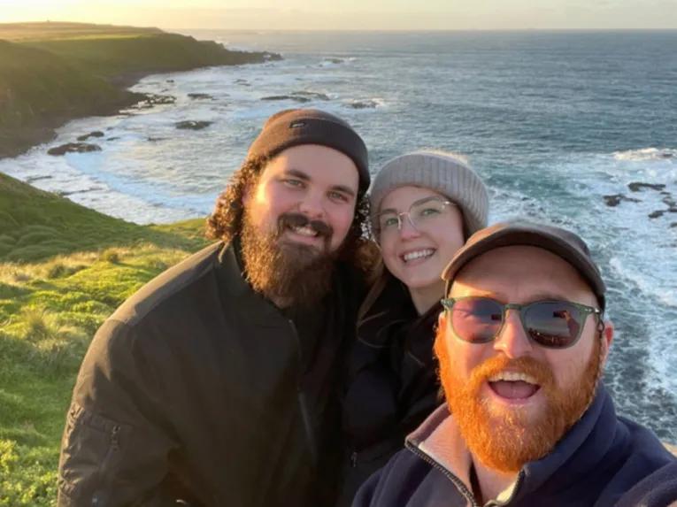 Tour guide with guests at the Nobbies lookout on Phillip Island, with ocean cliffs in the background