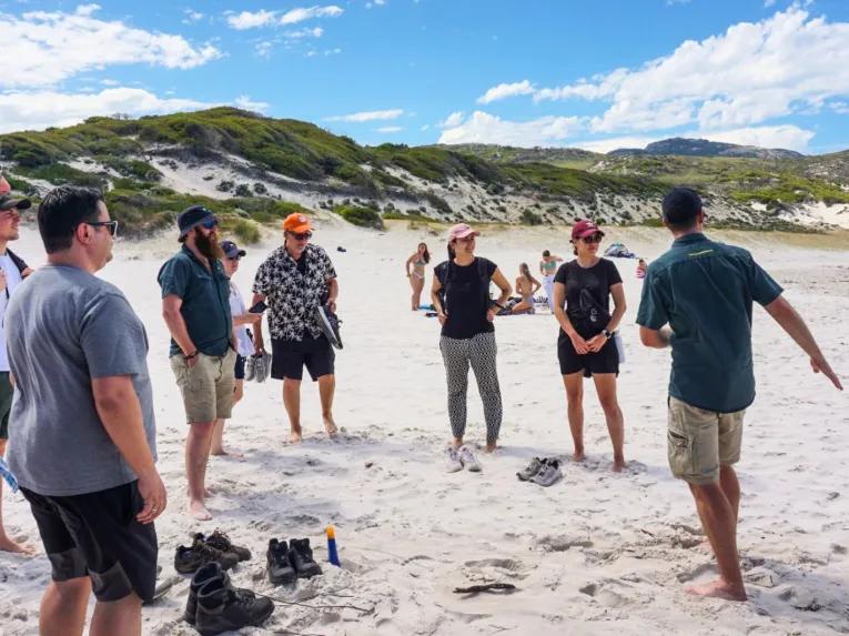 Guide leading the tour group along the iconic Squeaky Beach