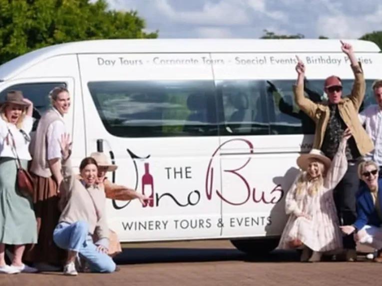 Group of happy people posing in front of The Vino Bus during the Explore Tamborine Tour