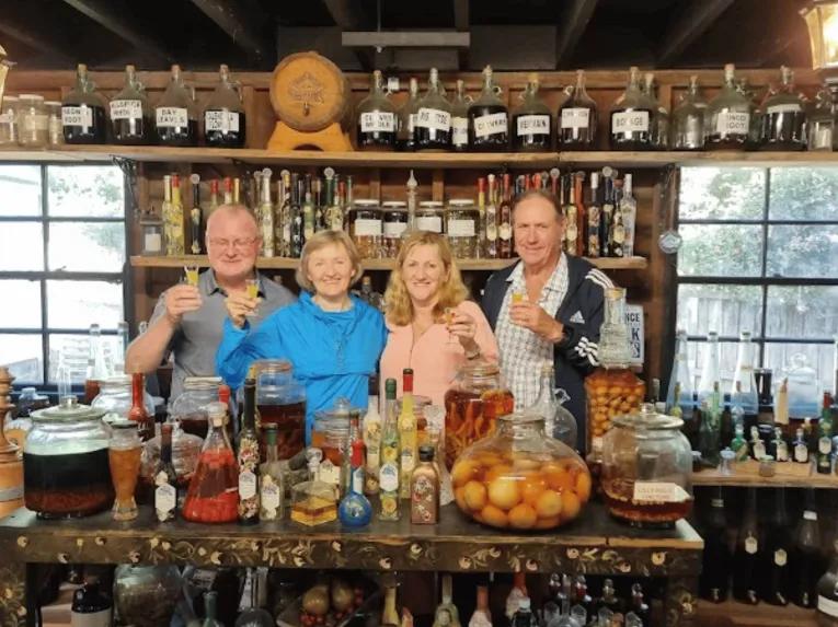 Four people behind a bar smiling during a winery visit on the Explore Tamborine Tour