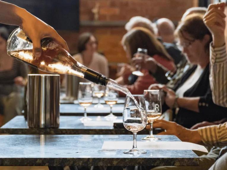 People seated at tables at Rochford Wines as wine is poured into a glass