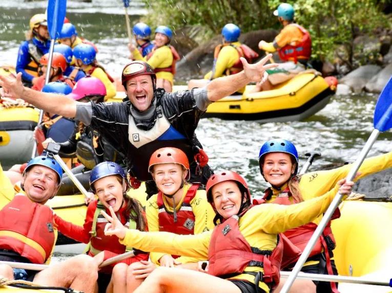 A group of happy people having fun on a raft at Barron River Rafting