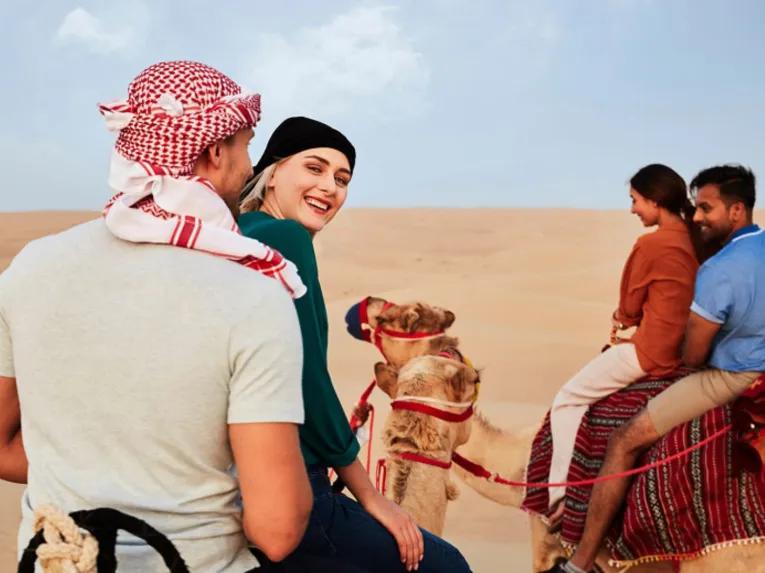 Guests enjoying a camel ride through the Dubai desert