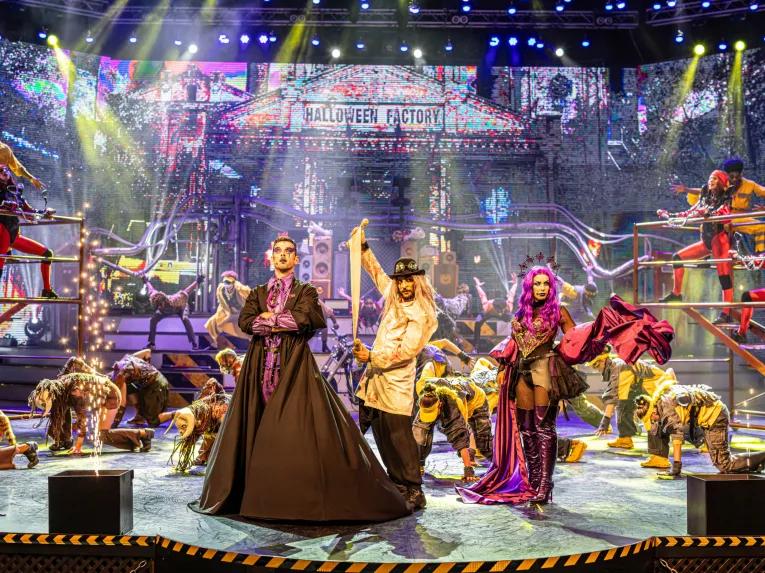 Halloween performers on a stage designed to look like a factory
