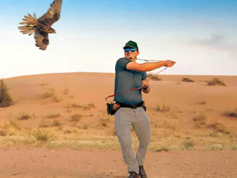 Man smiling with a falcon at Platinum Desert Safari Dubai