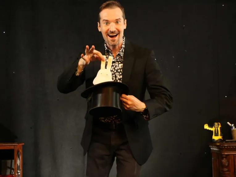 Magician performing a trick at The Outta Control Magic Dinner Show Orlando