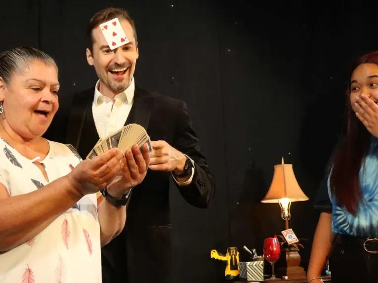 Amazed audience members watching a magician at The Outta Control Magic Dinner Show Orlando