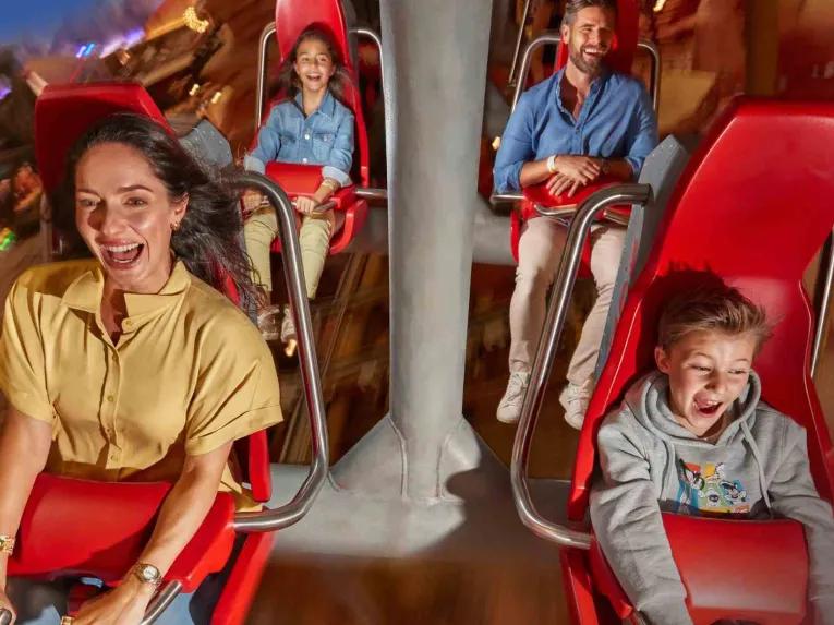 Guests enjoying the Fast and Furry-ous Roller Coaster at Warner Bros. World Abu Dhabi, smiling and having fun