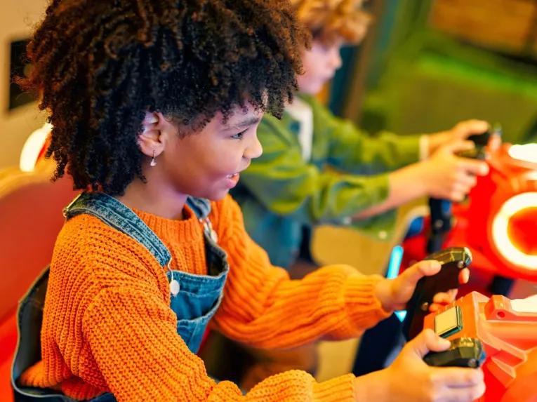 Girl enjoyong arcade games at Hilton Orlando Lake Buena Vista Disney Springs® Area