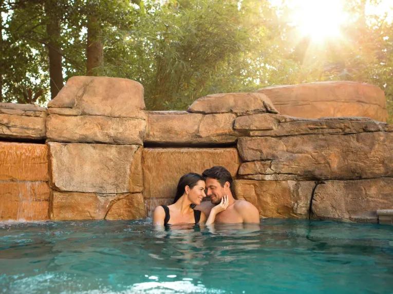 Couple in the outdoor pool at Hilton Orlando Lake Buena Vista Disney Springs® Area
