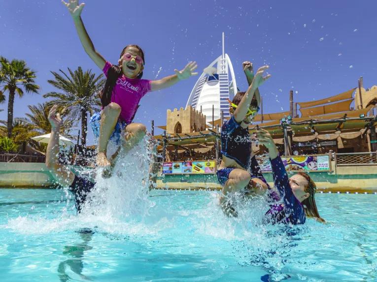Family smiling and having fun in the water at Wild Wadi Waterpark
