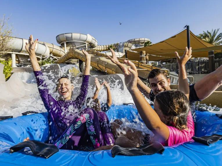 Family of four riding together in a water ring at Wild Wadi Waterpark