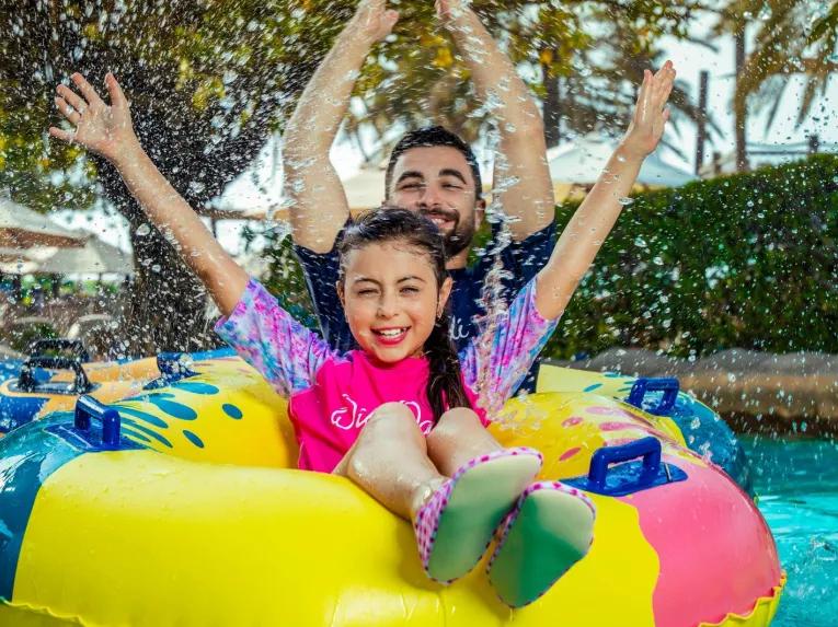 Man and child enjoying a water ring ride at Wild Wadi Waterpark in Dubai
