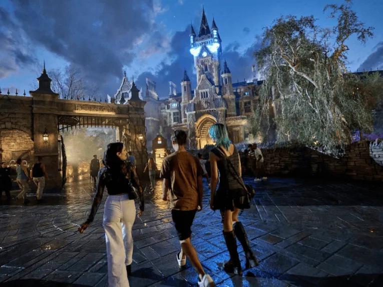 Guests walking toward a spooky, gothic-style castle at night
