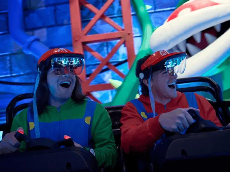 Two guests on a Mario-themed ride wearing AR visors
